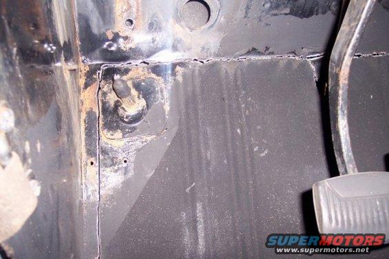 close-up of rusty floor pan and brake pedal assembly inside a vehicle