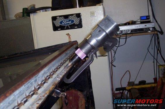Close-up of a tool with a Ford logo plate on a refrigerator in the background
