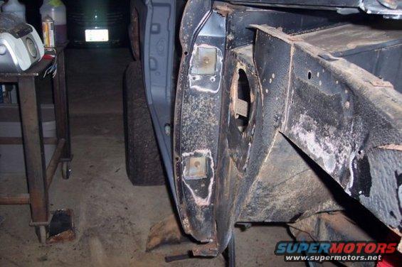 Close-up of rusty vehicle frame and fender mounting points