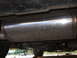 2002 Chevrolet Camaro - The underside of a vehicle shows the exhaust system, including the muffler and piping.