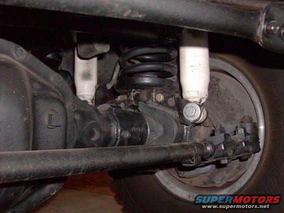 Close-up of rear axle, coil spring, and shock absorber assembly