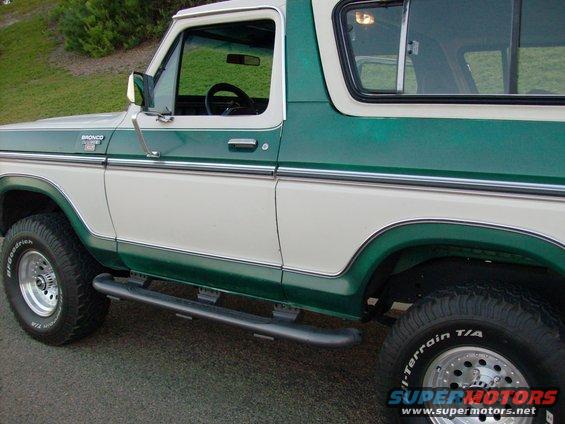 Green and white Ford Bronco, side view. Has running boards and BFGoodrich tires