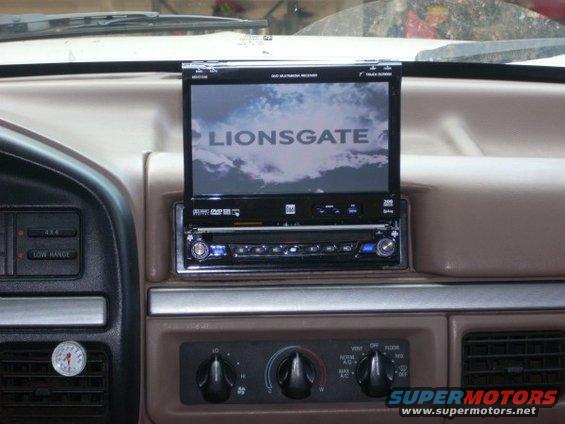1992 Ford Bronco interior showing dashboard with aftermarket DVD player and screen displaying "LIONSGATE"