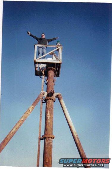 guy in a lift with arms out, blue sky