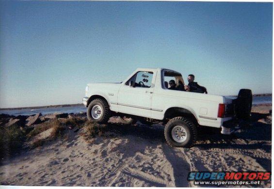 White 1992 Ford Bronco on a sandy dune overlooking the ocean