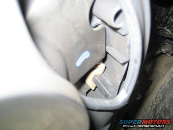 Close-up of a beige clip and blue mark inside a vehicle's interior