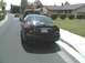 2002 Ford Taurus - Rear view of a 2002 Ford Taurus parked on a residential street. A red truck is in front.
