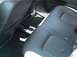 2002 Ford Taurus - The interior of a car with black leather seats and floor mats is shown, with a cup holder in the center console.