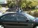 2002 Ford Taurus - Child pops out of the sunroof of a black 2002 Ford Taurus.