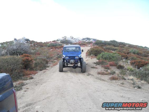 Blue Jeep Wrangler with winch on dirt road