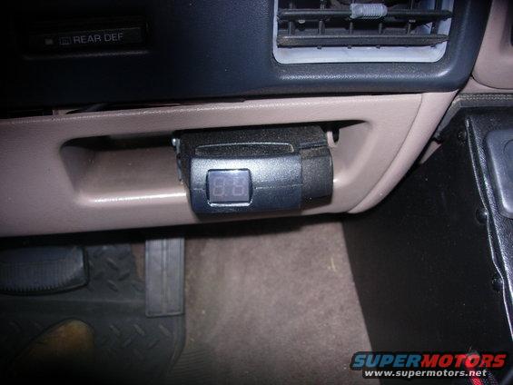 Digital gauge mounted in dashboard near air vents and 'REAR DEF' button