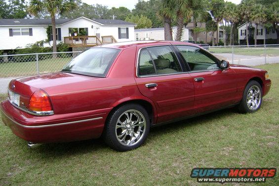 Red sedan, rear quarter view, showing a slight dent on the rear bumper