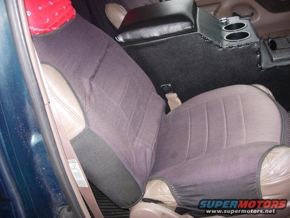 Interior view of vehicle seats with seat covers and a center console