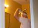 1992 Ford Bronco - A man is seen in a bathroom, holding a pipe and applying tape to his head.
