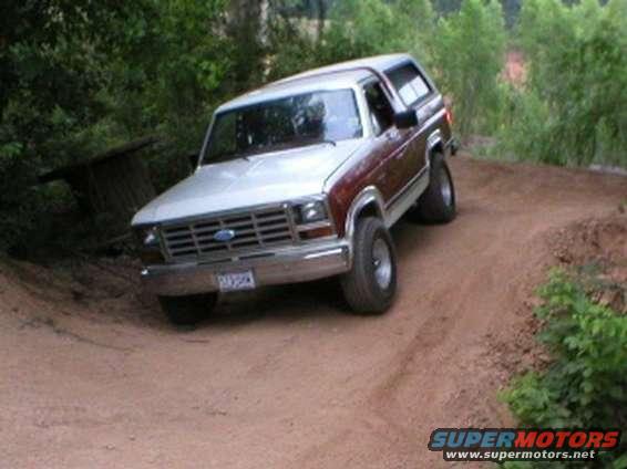 Ford Bronco on dirt road, two-tone paint, chrome grille, off-road tires