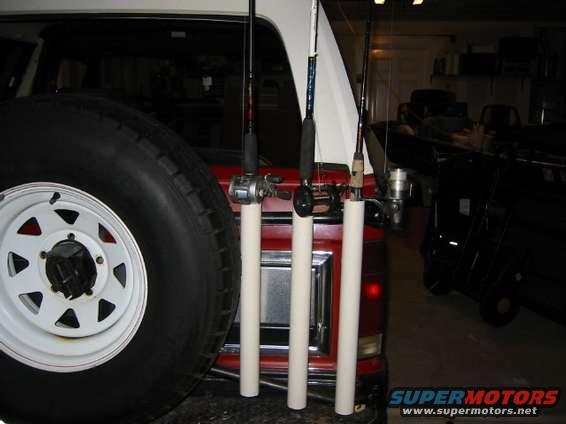 Spare tire and fishing rods attached to the back of a red SUV