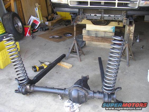 front axle assembly with coil springs removed, vehicle is on jack stands