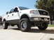 2005 Ford F-150 - White 2005 Ford F-150 pickup truck with a lift kit and chrome wheels.