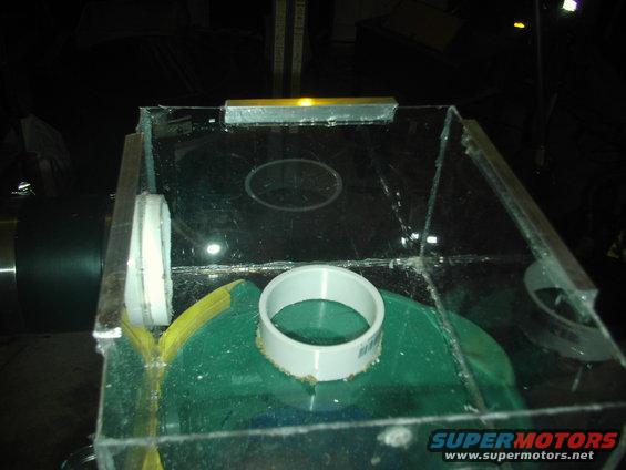 Clear plastic enclosure with PVC pipe fittings and a green base