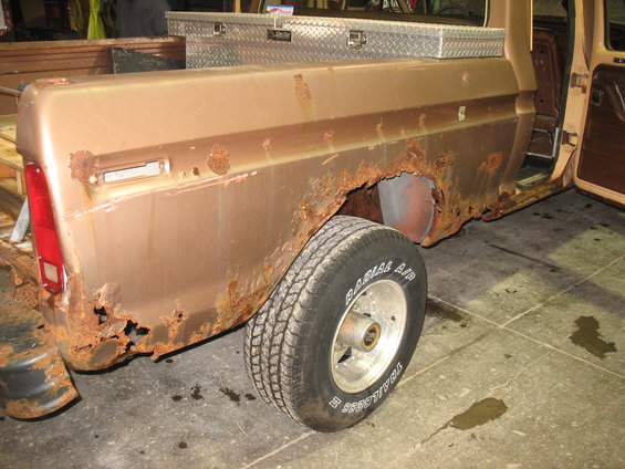 Brown 1973 Ford F-250 pickup truck with extensive rust on the rear quarter panel and bed