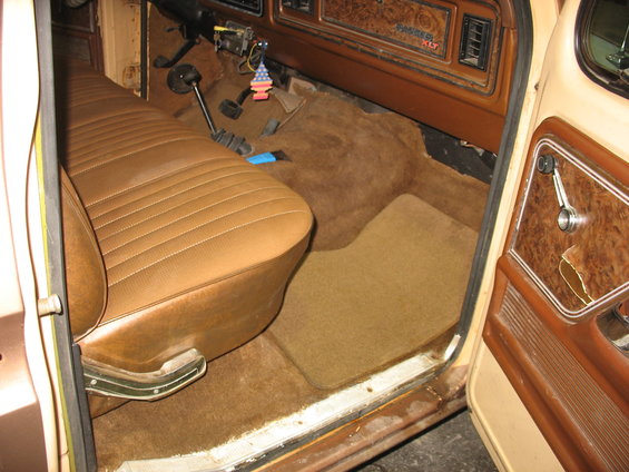 1978 Ford F-250 interior with brown vinyl bench seat, brown carpet, and wood-grain trim dashboard