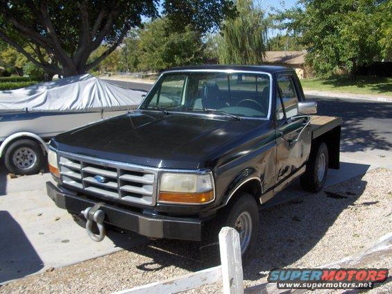 Black flatbed truck, front 3/4 view. Grille indicates 1995 model year