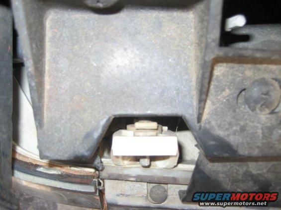 Headlight mounting bracket with white plastic clip and metal screws