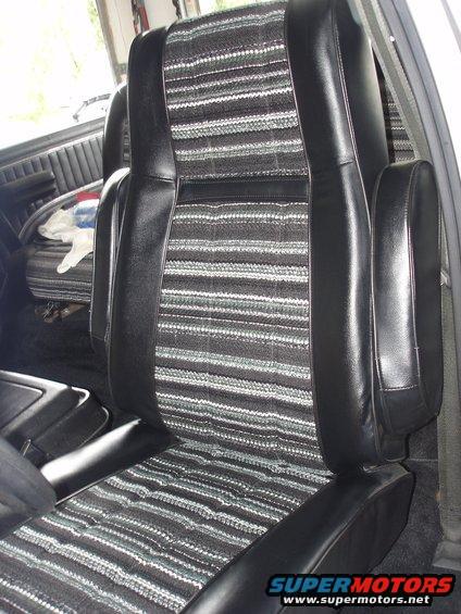 Vehicle interior showing front seats with black vinyl bolsters and striped fabric inserts