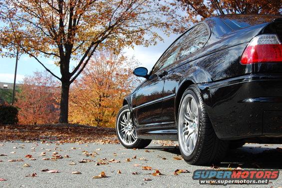 Black 2002 BMW M3 coupe, rear quarter view, parked on asphalt with fallen autumn leaves