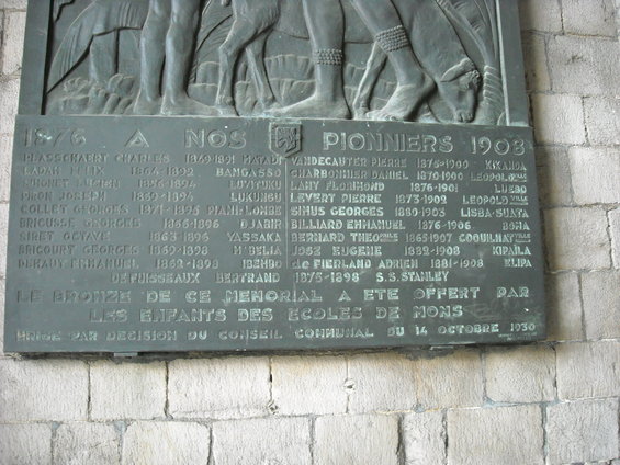 Bronze plaque listing names and dates, with figures and animals at the top