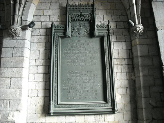 Ornate bronze memorial plaque mounted on a stone wall, detailing historical events