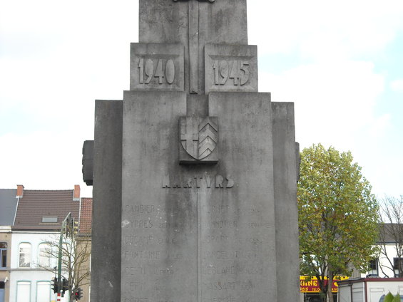 Stone war memorial with dates 1940 and 1945, a shield emblem, and names inscribed