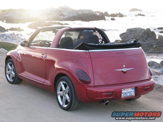 Red 2005 Chrysler PT Cruiser convertible parked on a dirt road near a rocky coastline