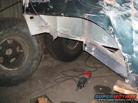 1994 Jeep YJ rear quarter panel showing damage and repair with a reciprocating saw on the floor
