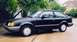 1989 Ford Escort - Side view of a black 1989 Ford Escort hatchback parked outside.