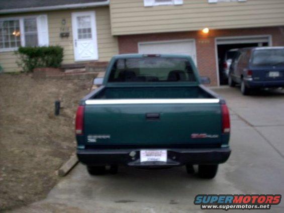 Green 1995 GMC Sierra 1500 pickup truck, rear view, parked in driveway