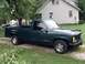 1995 GMC Sierra 1500 - This 1995 GMC Sierra 1500 pickup truck is parked on a gravel driveway next to a house.