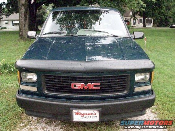 Dark green 1995 GMC Sierra 1500 front view with a bug deflector and a license plate frame from Wagner's Auto Sales