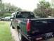 1995 GMC Sierra 1500 - A dark green pickup truck is parked on a gravel driveway with a person standing by the driver's side door.