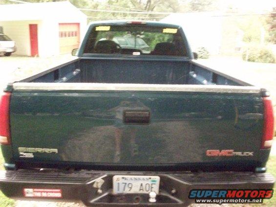 Dark green 1995 GMC Sierra pickup truck rear view with Kansas license plate 179 AOE