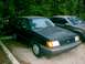 1989 Ford Escort - A black 1989 Ford Escort is parked outside next to another vehicle.