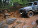 1989 Ford Bronco - A classic Ford Bronco navigates a challenging off-road course through a forest.