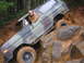 1989 Ford Bronco - A driver navigates a camouflaged 1978 Ford Bronco over a challenging rocky obstacle.