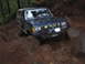 1989 Ford Bronco - Ford Bronco tackling a challenging off-road course with mud and rocks.