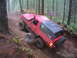 1989 Ford Bronco - A red 1989 Ford Bronco navigates a challenging, muddy off-road course in a forest.