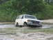 1989 Ford Bronco - White Ford Bronco navigating a muddy off-road course.
