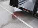 1989 Ford Bronco - A puddle of red fluid stains the asphalt near a trailer hitch, with a white line marking the parking space.