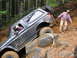 1979 Ford Bronco - A black SUV is shown struggling on a steep, rocky incline during an off-road excursion.
