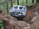 1979 Ford Bronco - This modified SUV is tackling a challenging off-road course with steep inclines and large rocks.