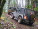 1979 Ford Bronco - Two off-road vehicles navigate a muddy forest trail, with a Jeep in the foreground and a Ford Bronco following behind it appears to be foll…